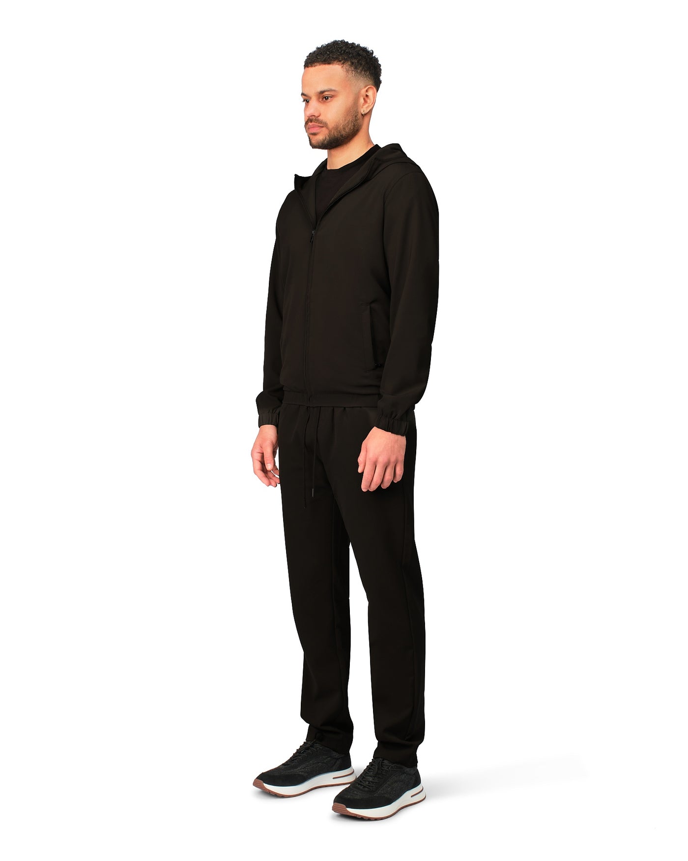 Man wearing a black tracksuit on a white background