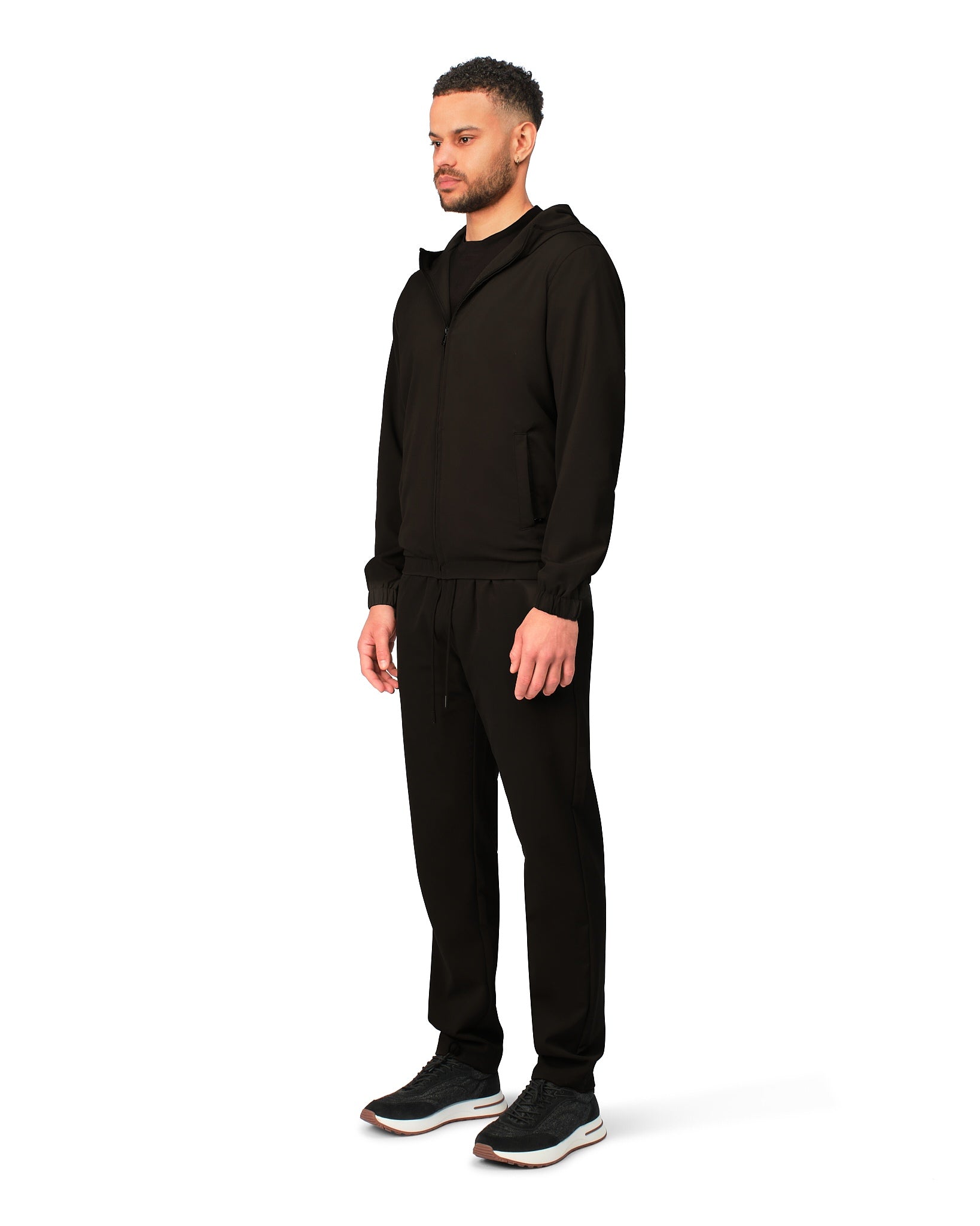 Man wearing a black tracksuit on a white background