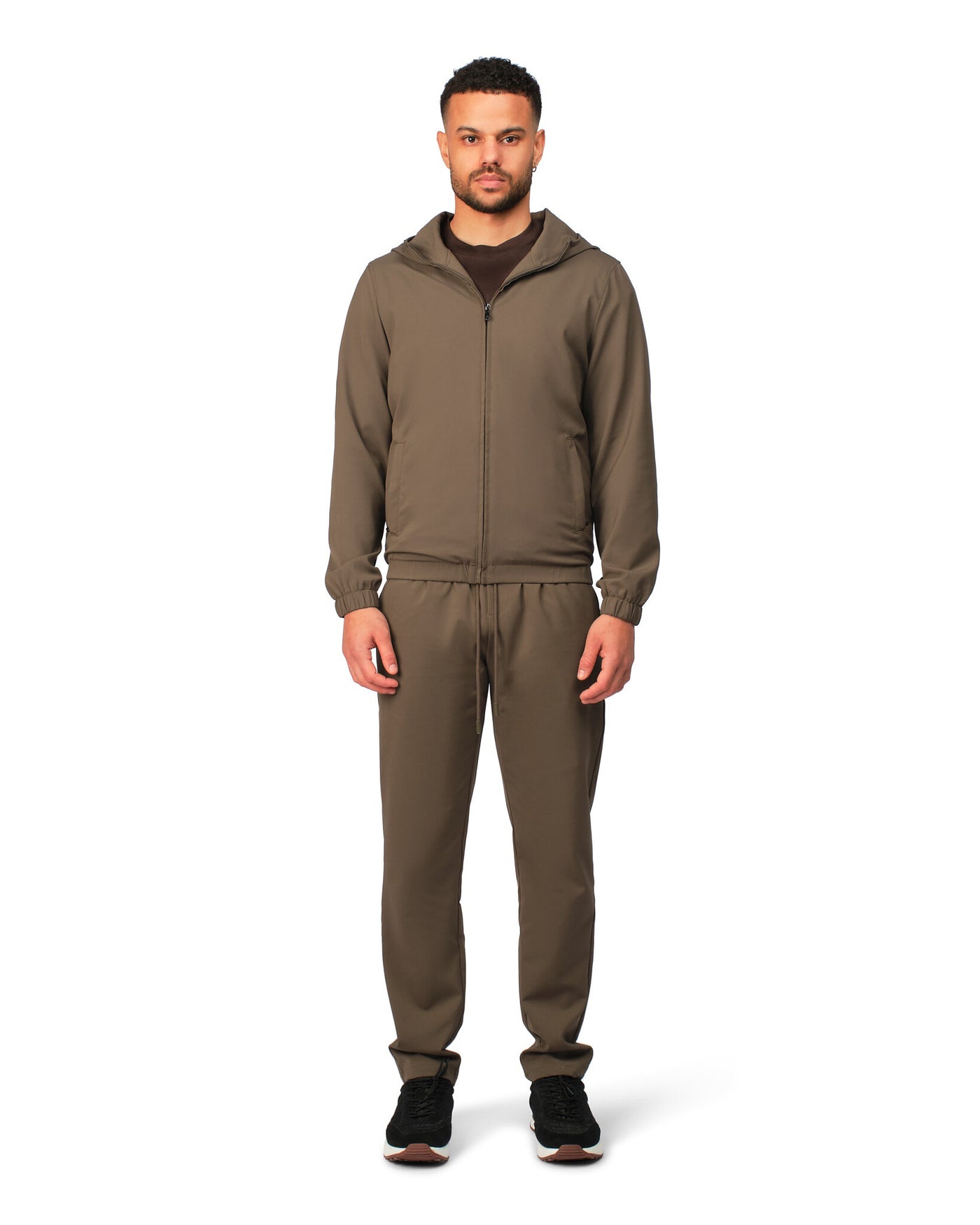 Man wearing a brown tracksuit on a white background