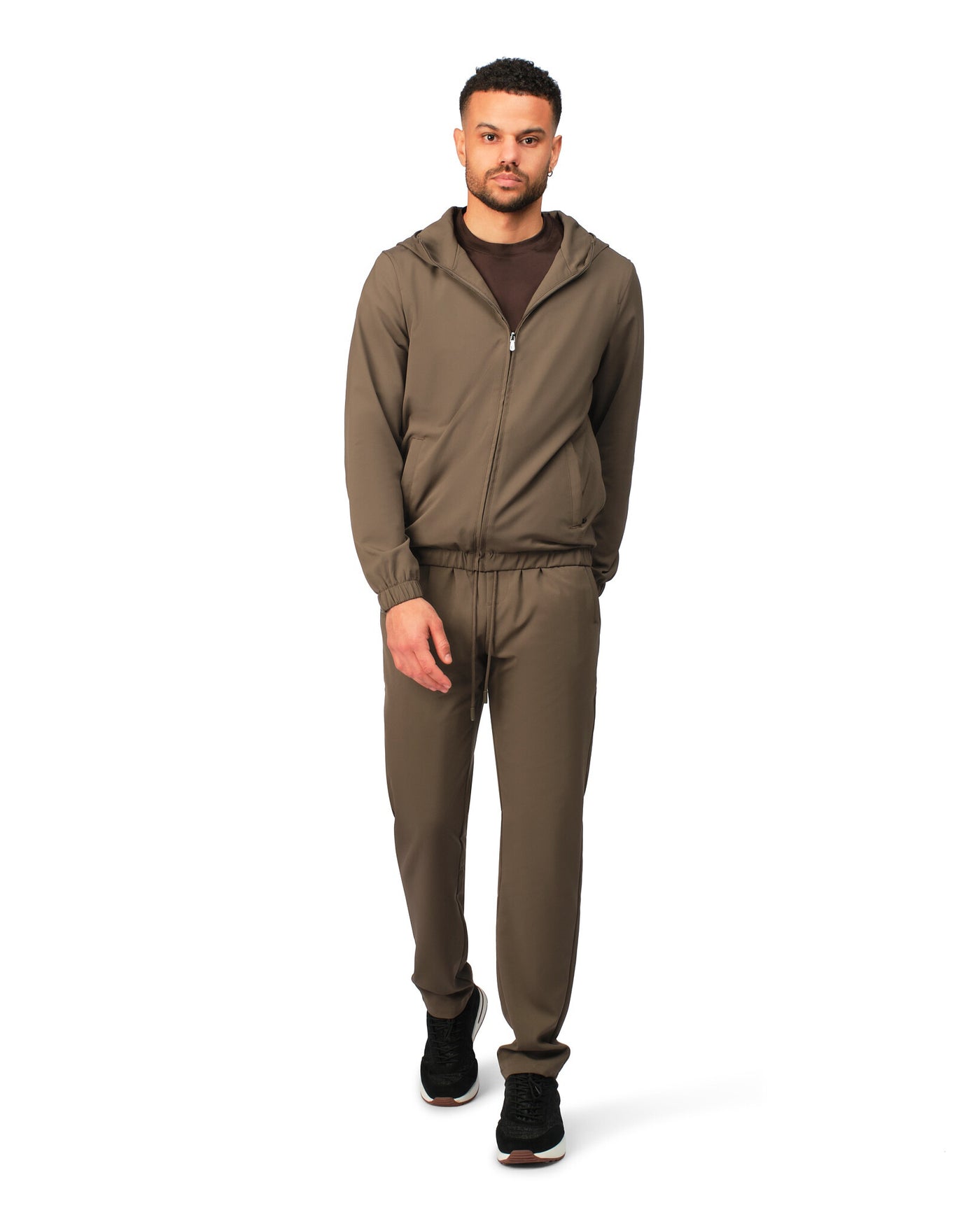 Man wearing a brown tracksuit on a white background