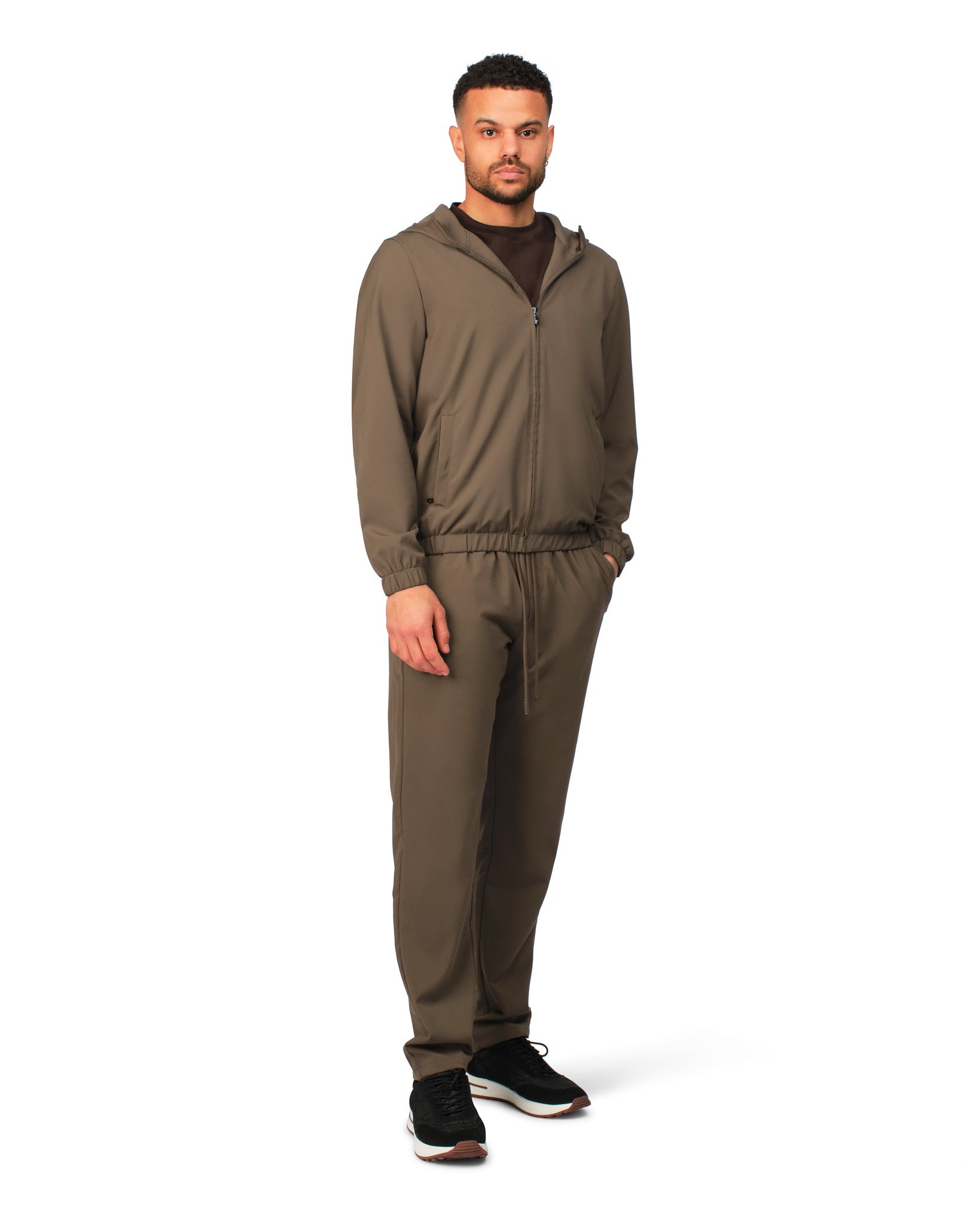 Man wearing a brown tracksuit on a white background