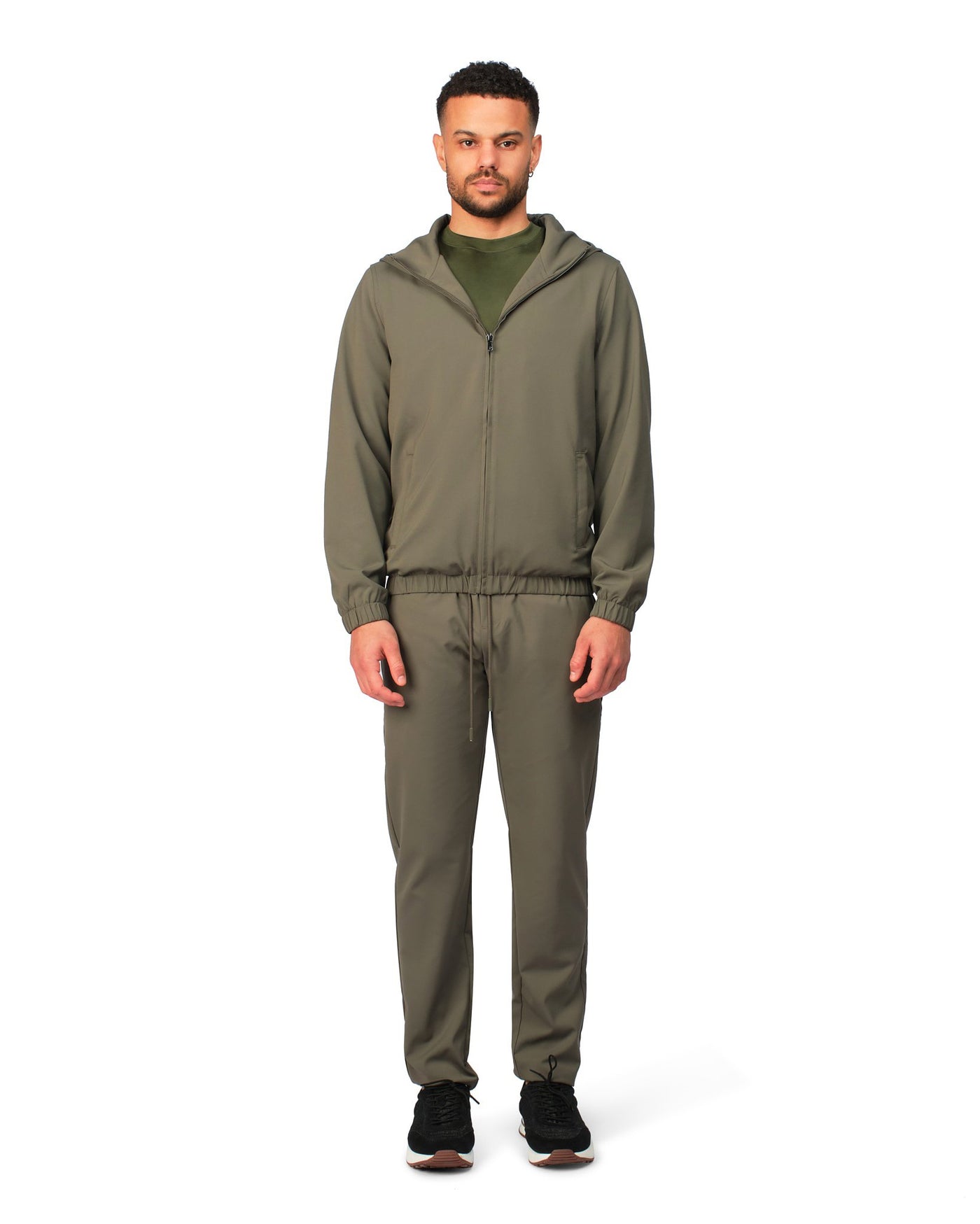 Man wearing a green tracksuit on a white background
