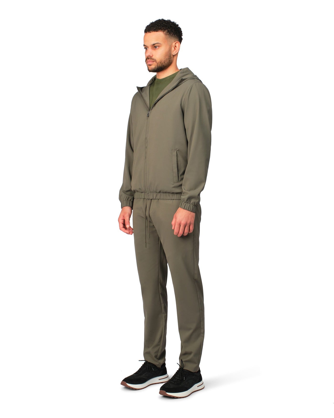 Man wearing a green tracksuit on a white background