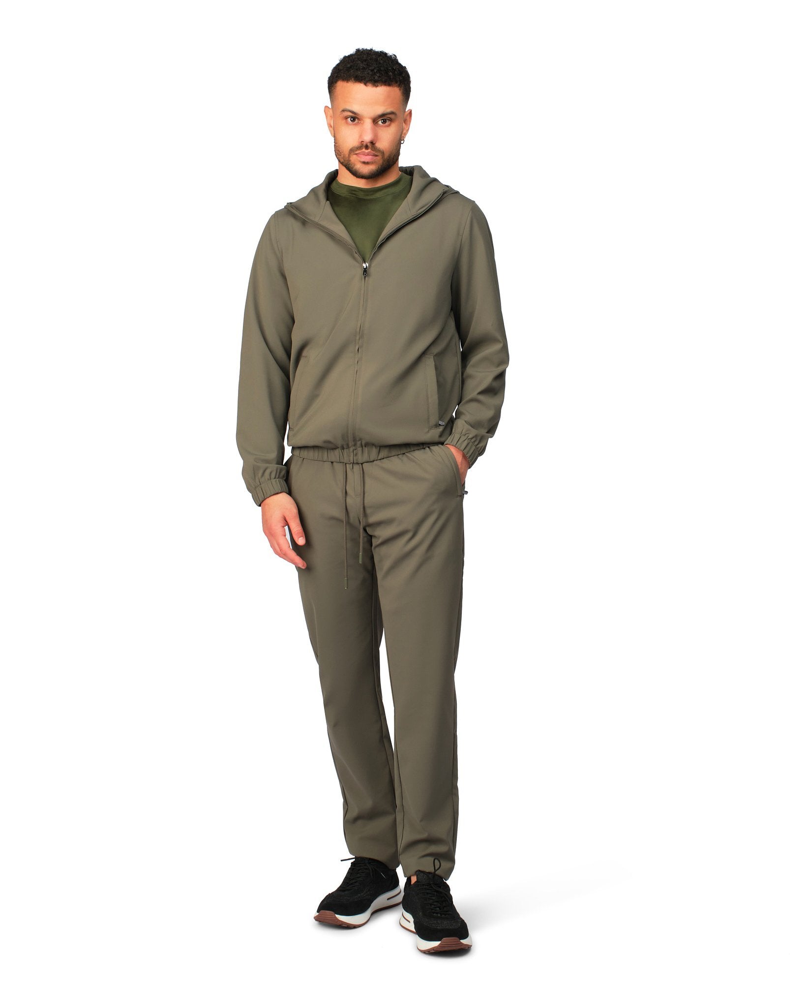 Man wearing a green tracksuit on a white background
