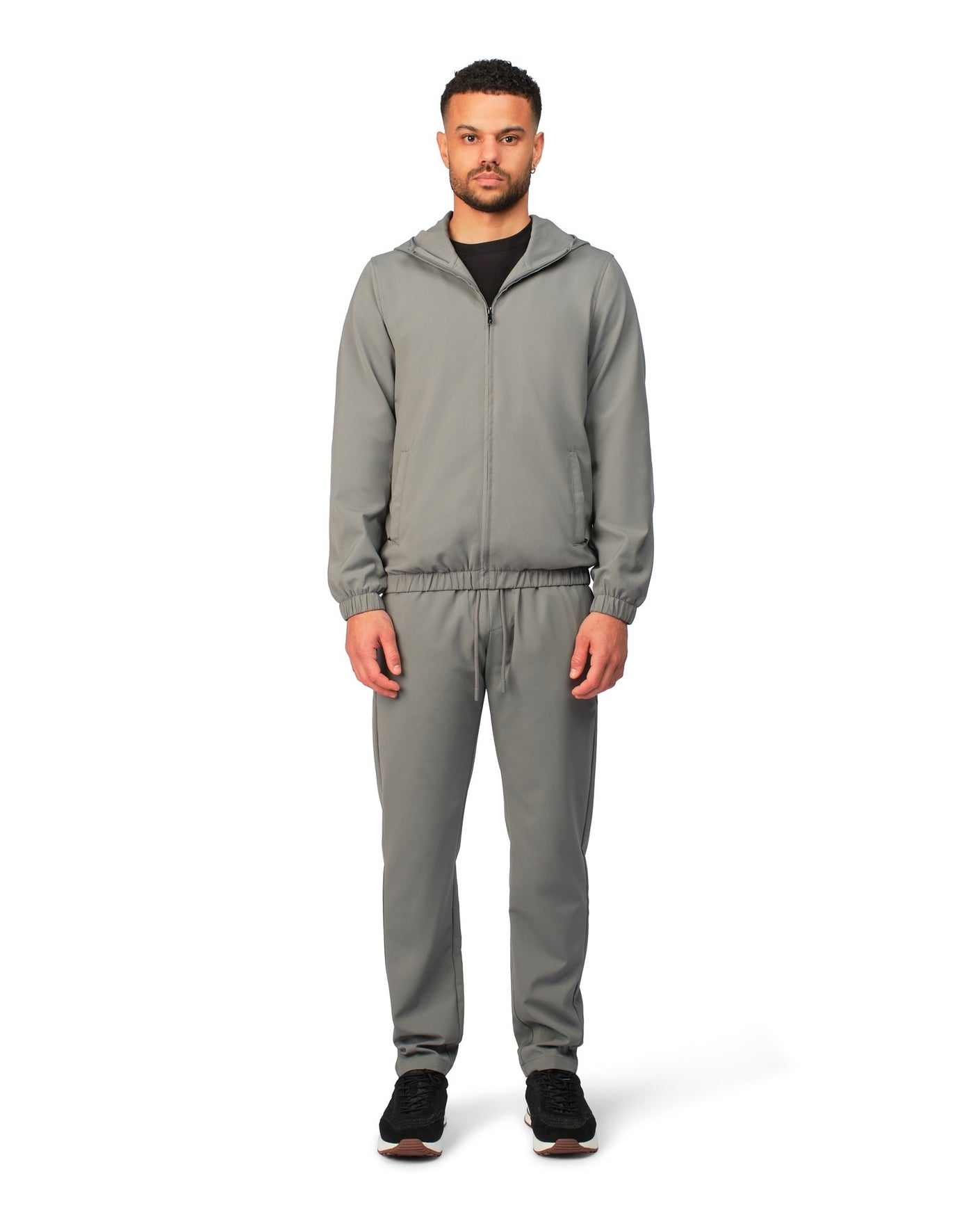Man wearing a gray tracksuit on a white background