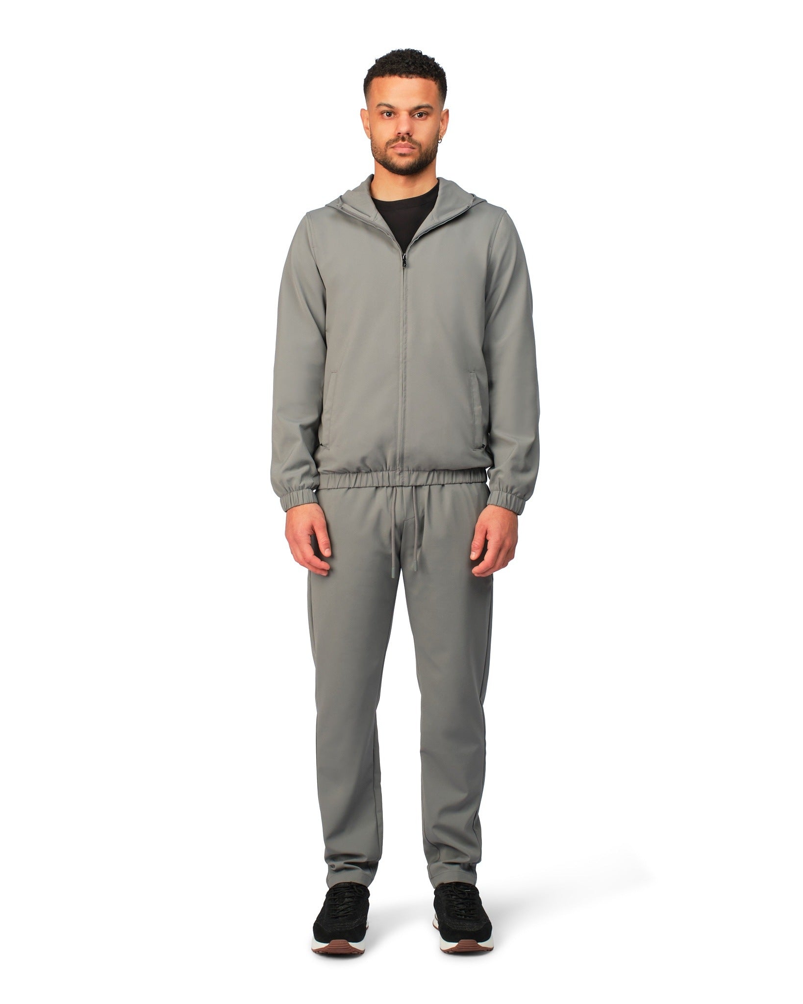 Man wearing a gray tracksuit on a white background
