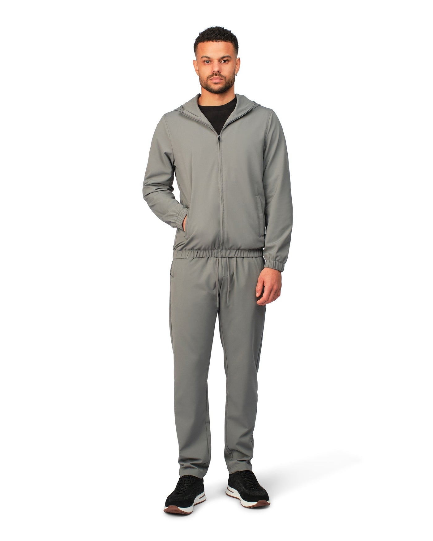Man wearing a gray tracksuit on a white background