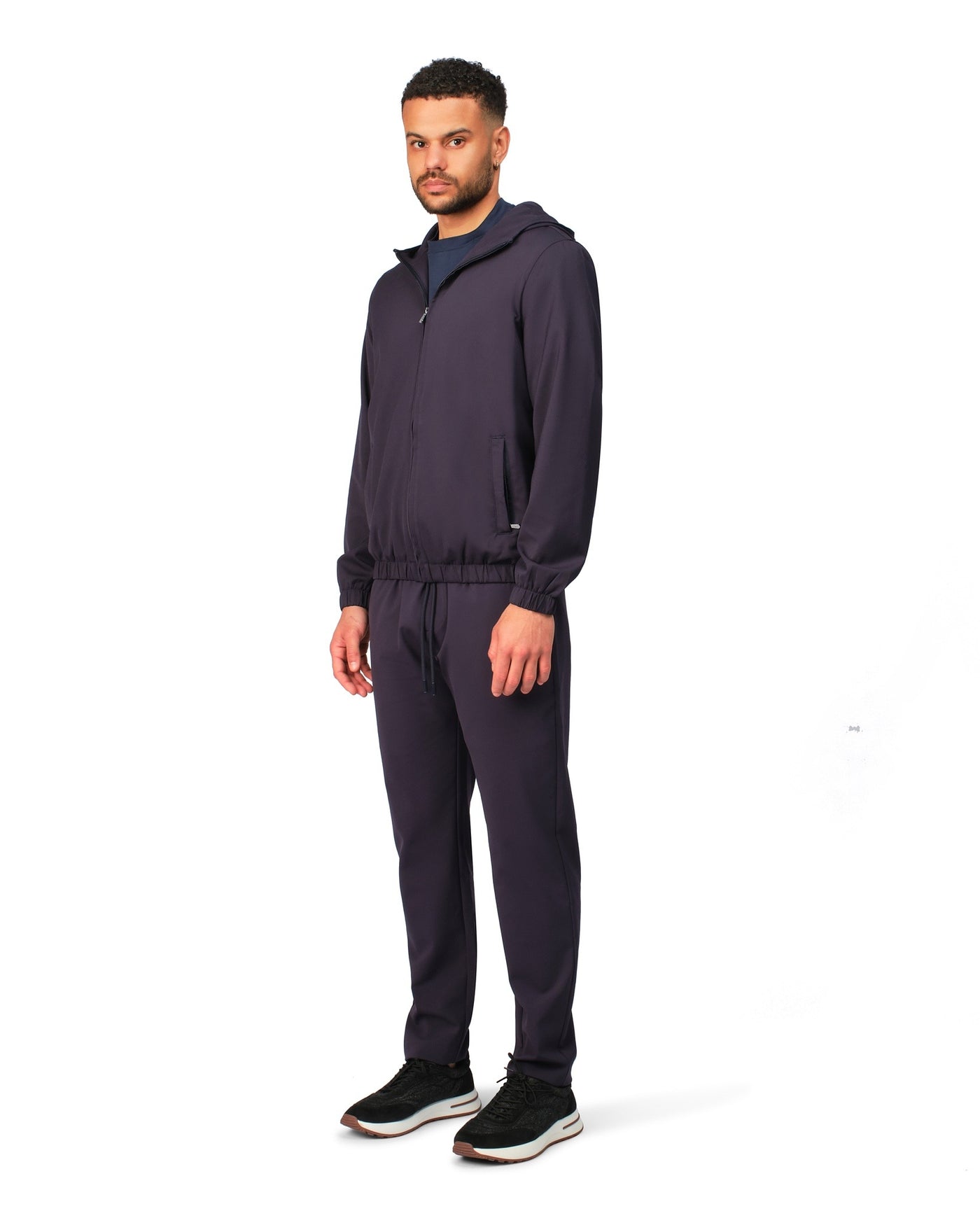 Man wearing a dark tracksuit on a white background