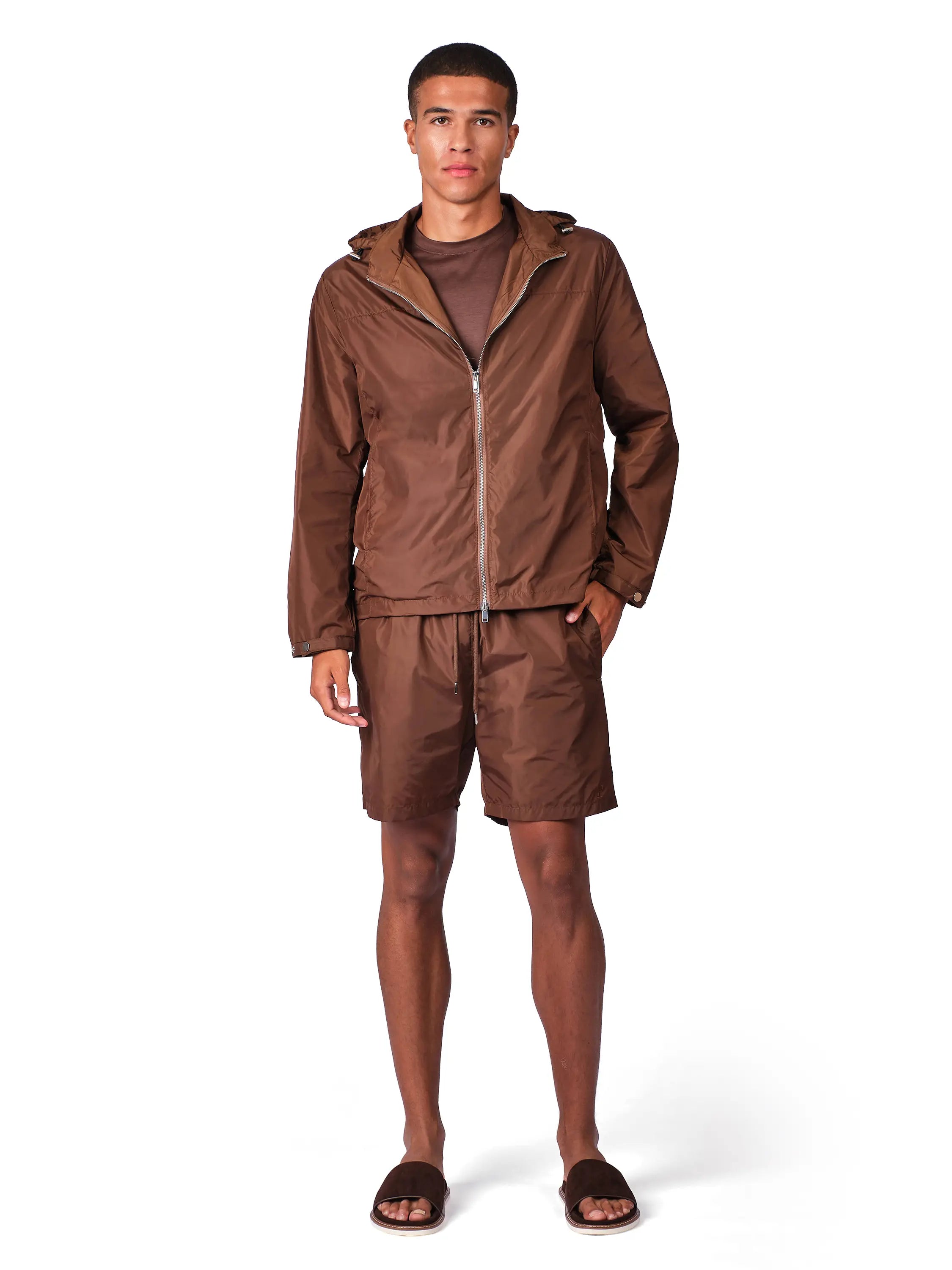 Man wearing a brown windbreaker with matching shorts