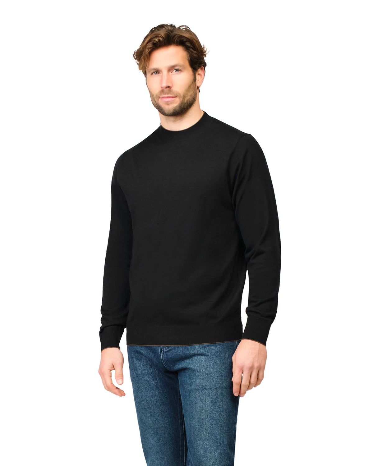 Man wearing a black sweater and blue jeans on a white background