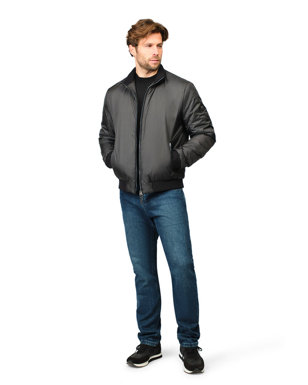 Man wearing a black jacket and blue jeans on a white background