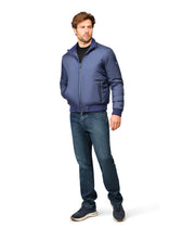 Man wearing a blue jacket and jeans on a white background