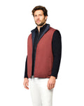 Man wearing a red vest over a black shirt on a white background