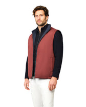 Man wearing a red vest over a black shirt on a white background