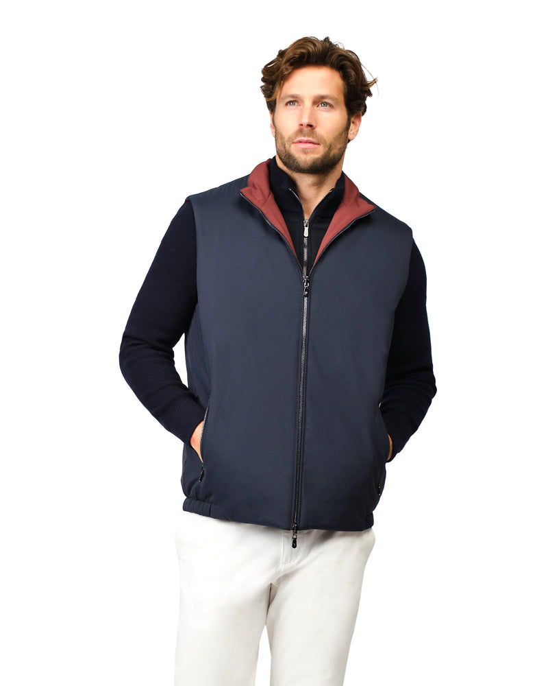 Man wearing a navy blue vest with a red interior on a white background