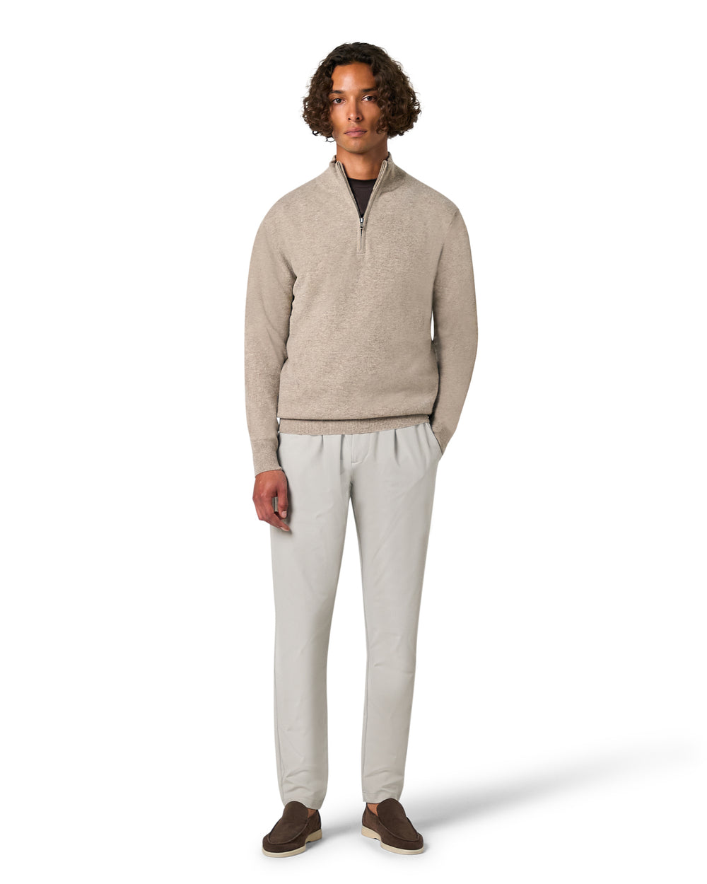 Man wearing a beige sweater and light gray pants