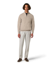 Man wearing a beige sweater and light gray pants