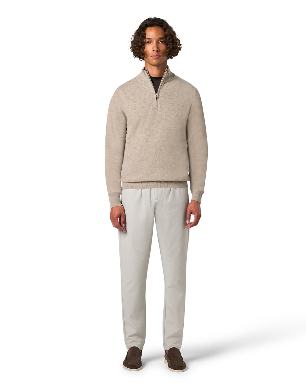 Man wearing a beige sweater and light gray pants