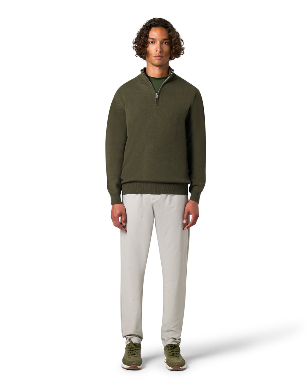 Man wearing a green sweater and white pants