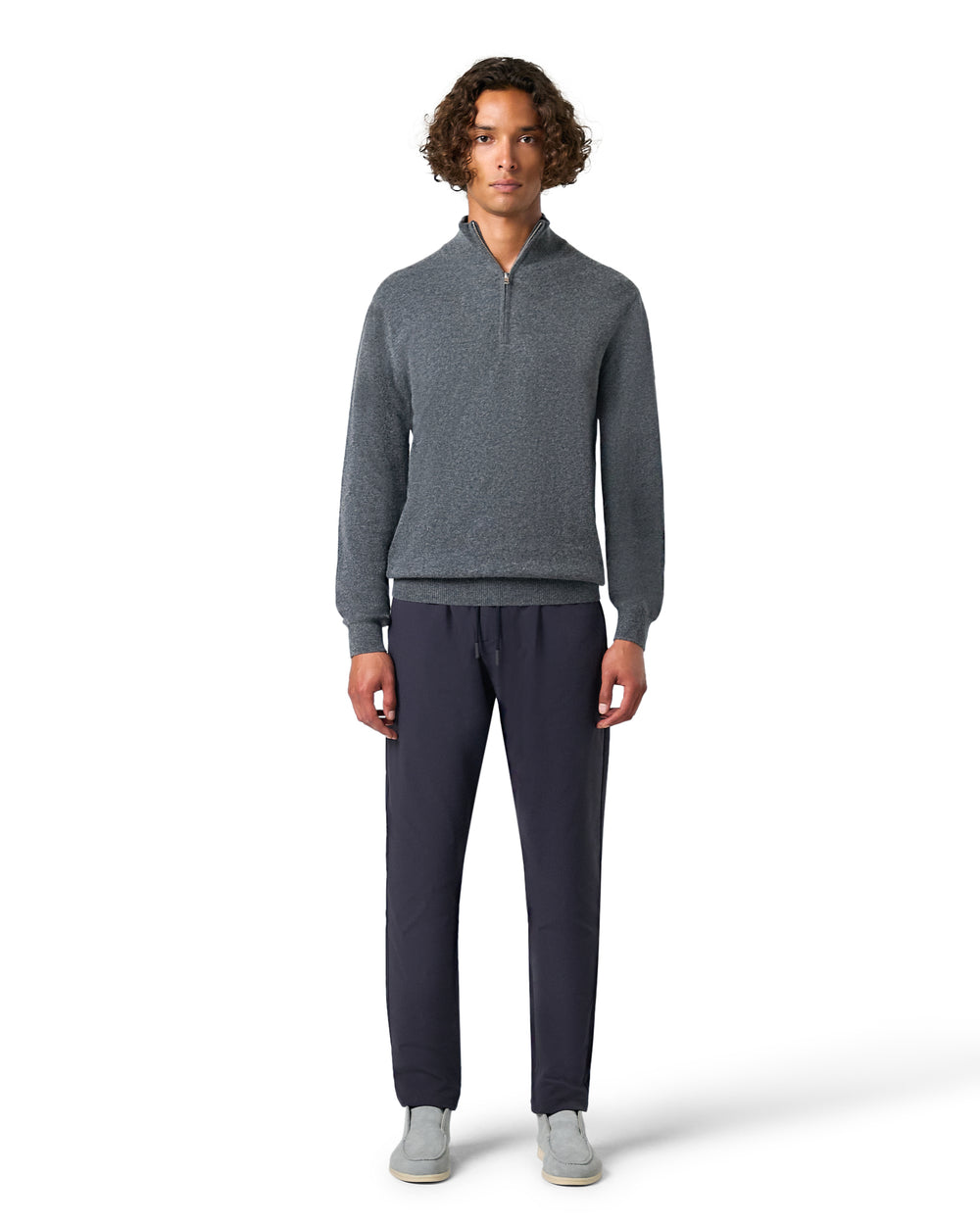 Man wearing a gray sweater and dark pants 