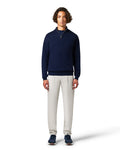 Man wearing a navy sweater and light gray pants