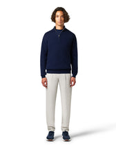 Man wearing a navy sweater and light gray pants