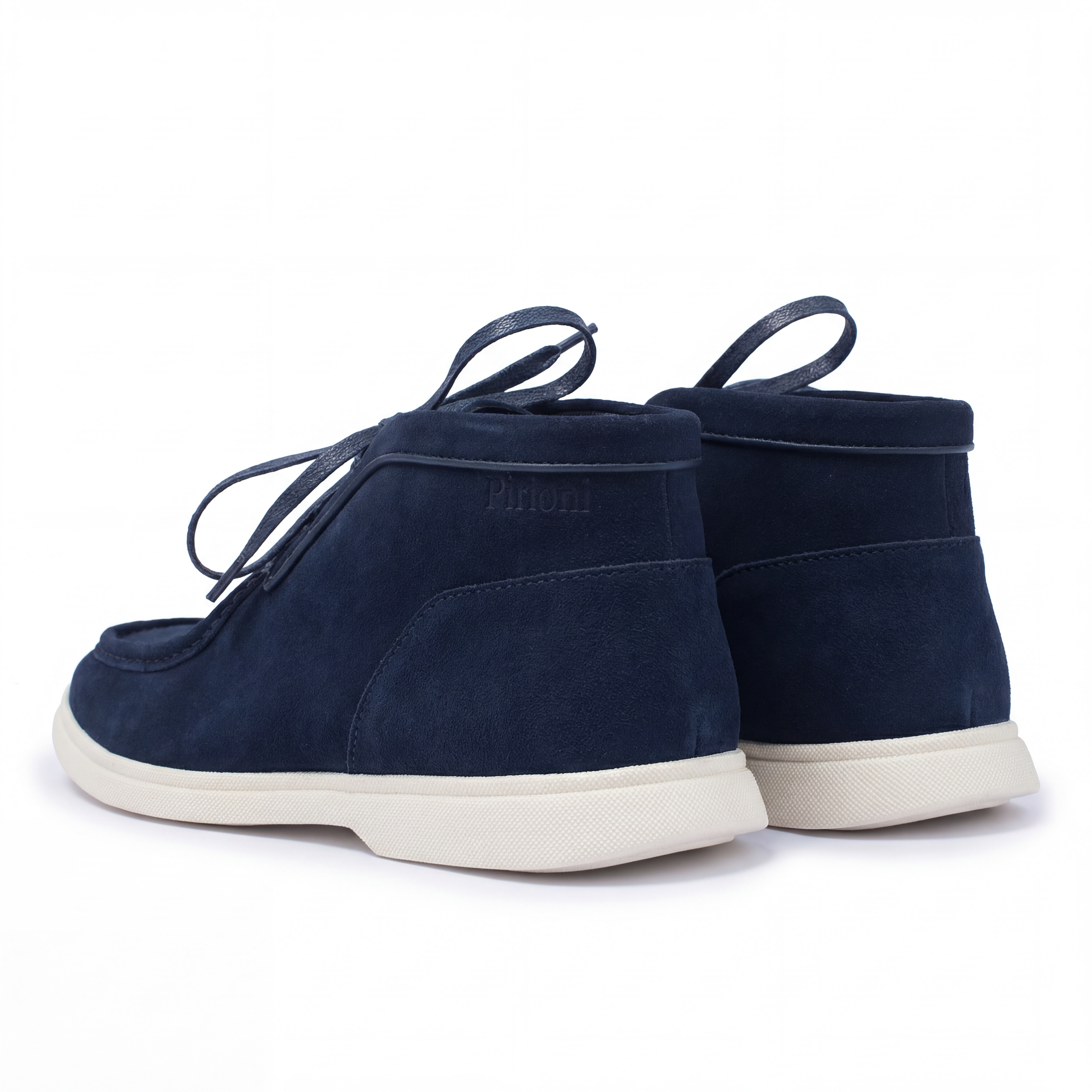 Pair of navy blue suede shoes with white soles on a white background