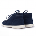 Pair of navy blue suede shoes with white soles on a white background