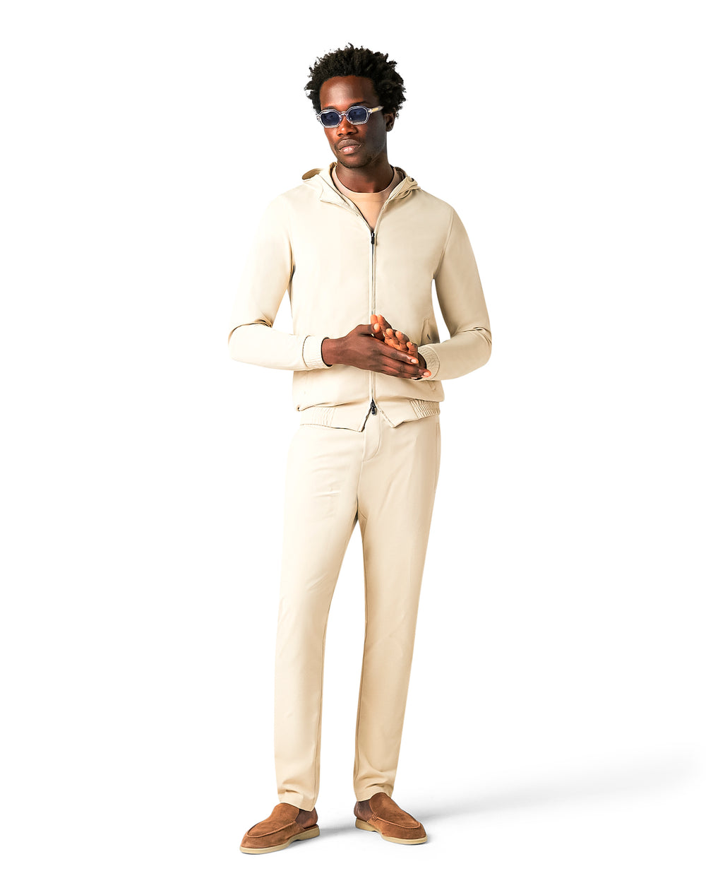 Man wearing a beige hoodie and pants on a white background