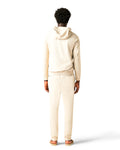 Person wearing a beige tracksuit on a white background