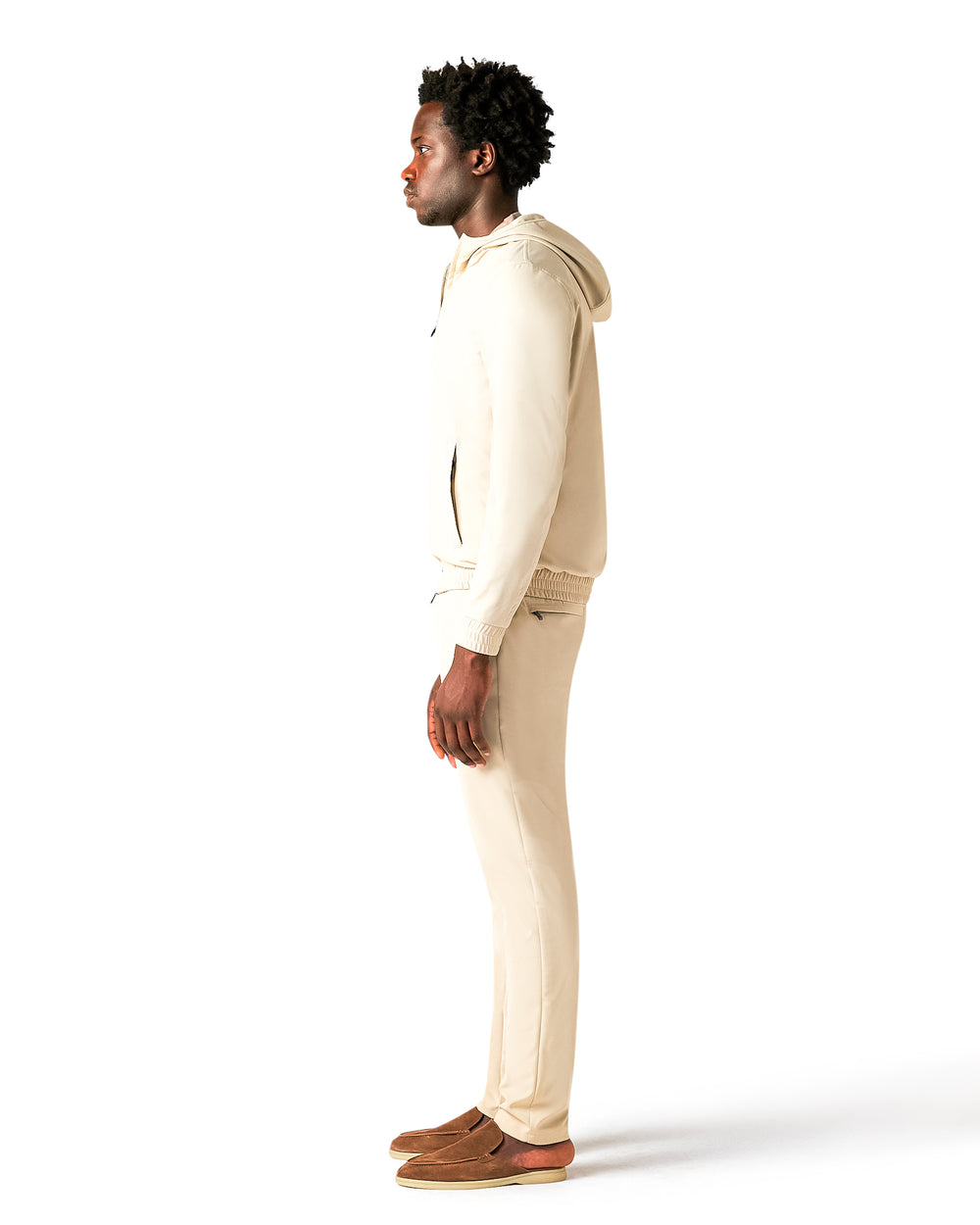 Man wearing a beige hoodie and pants on a white background