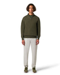 Man wearing a green sweater and white pants on a white background