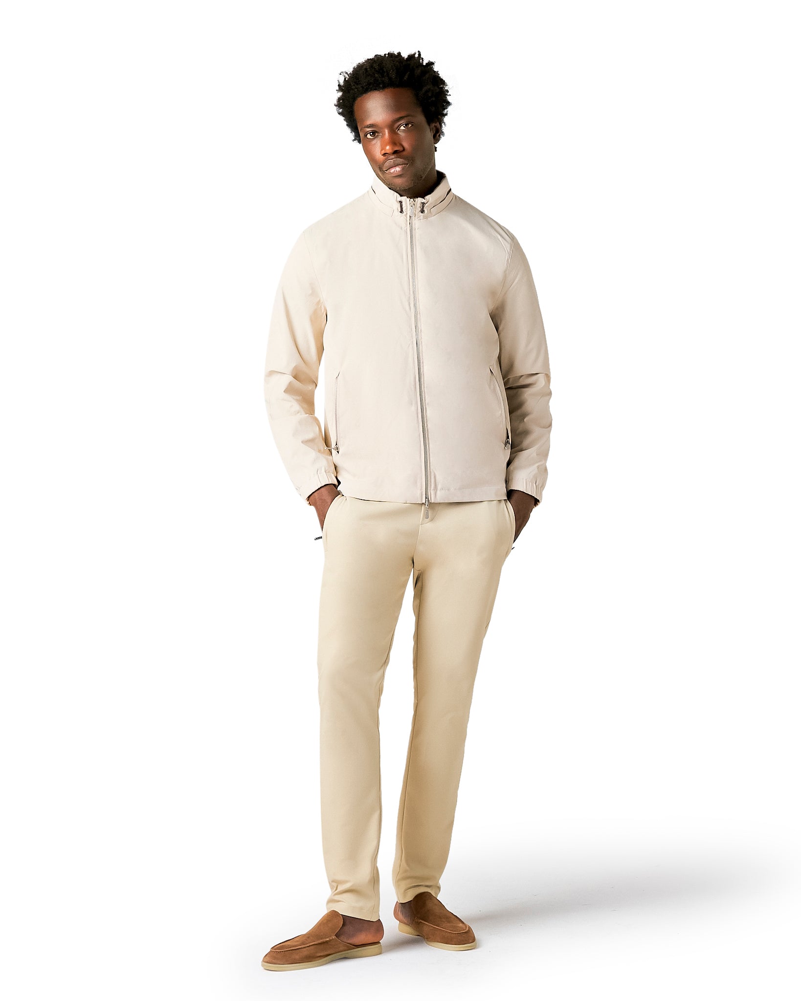 Man wearing a beige jacket and pants on a white background