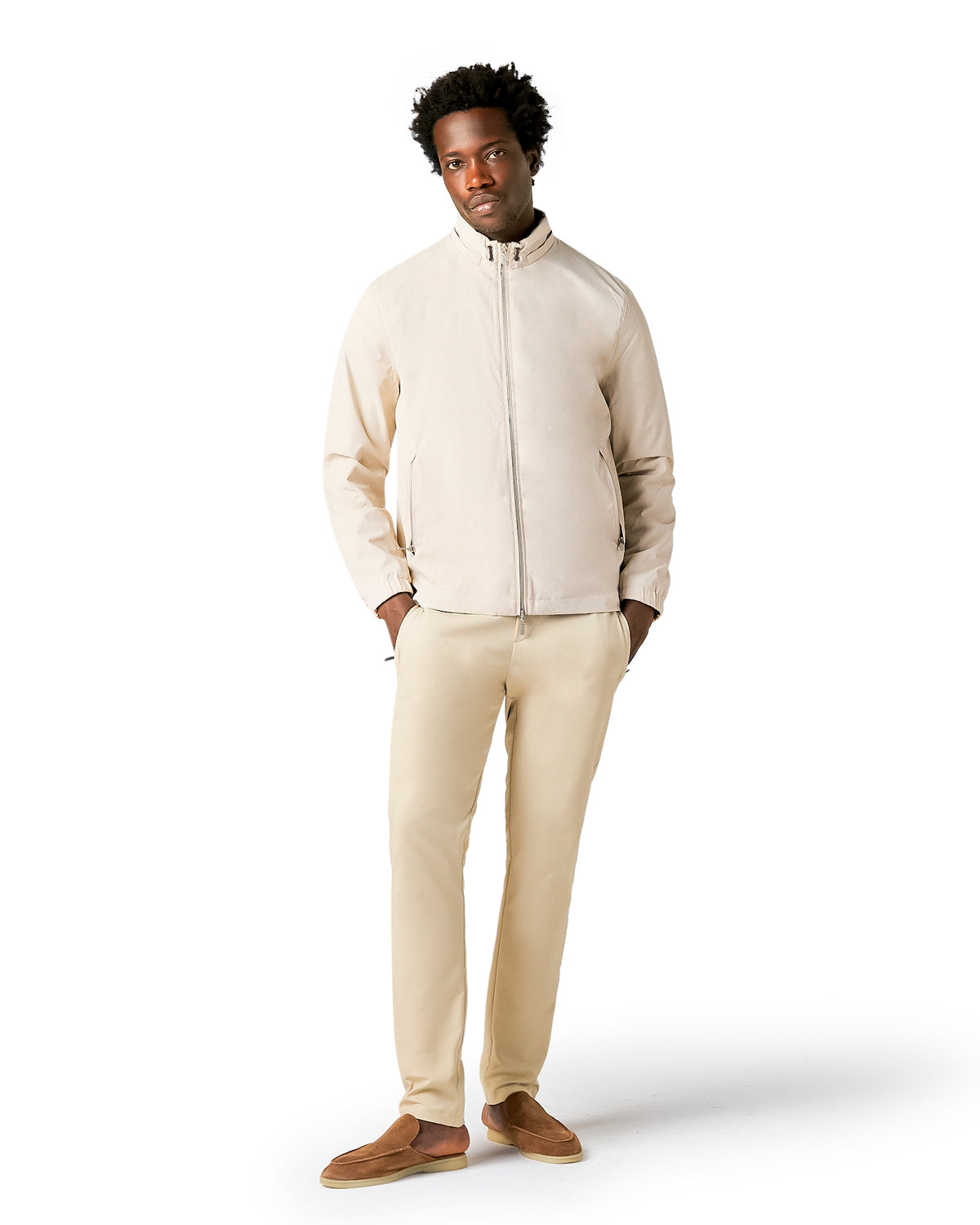Man wearing a beige jacket and pants on a white background