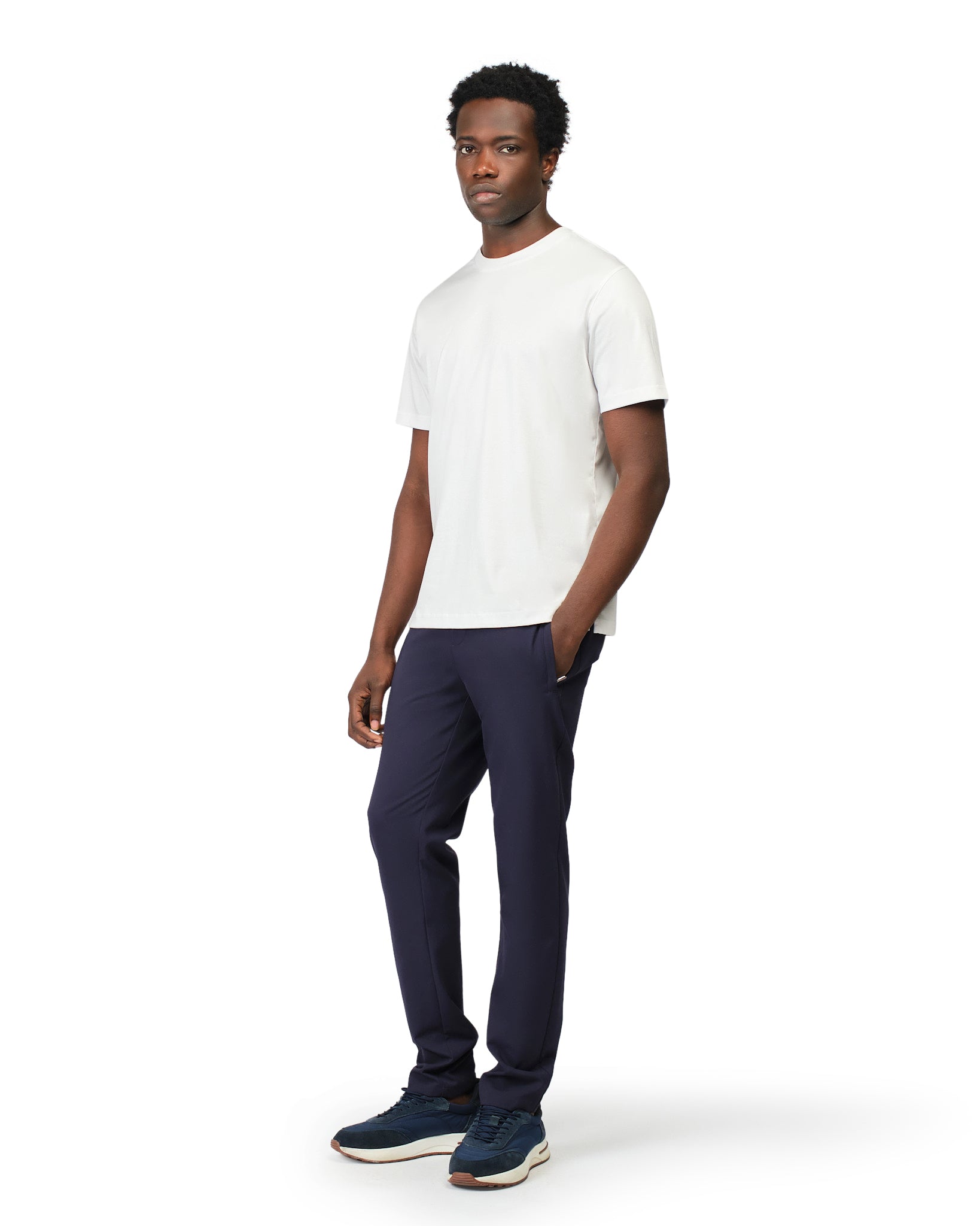 Man wearing a white t-shirt and navy pants on a white background