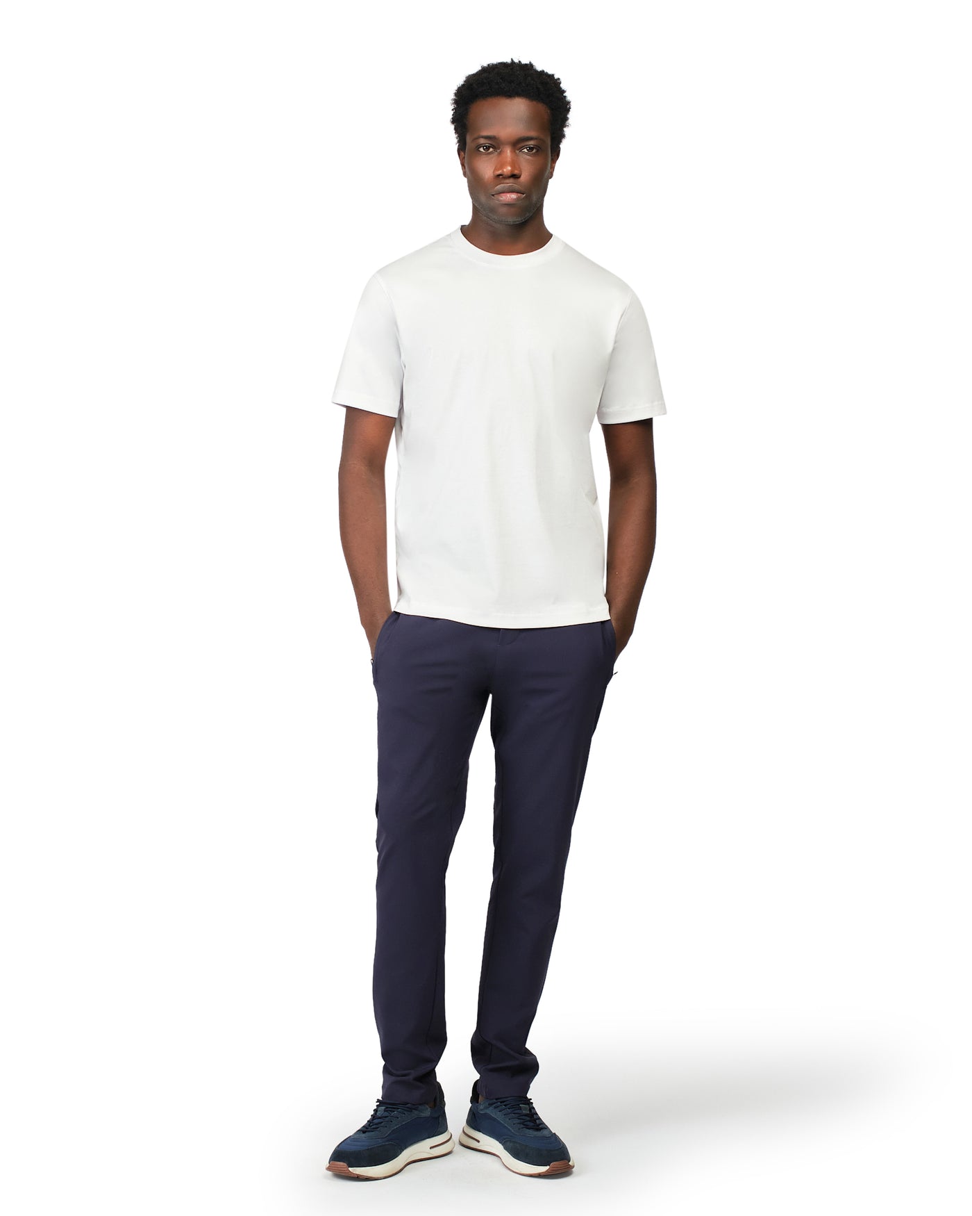 Man wearing a white t-shirt and navy pants on a white background