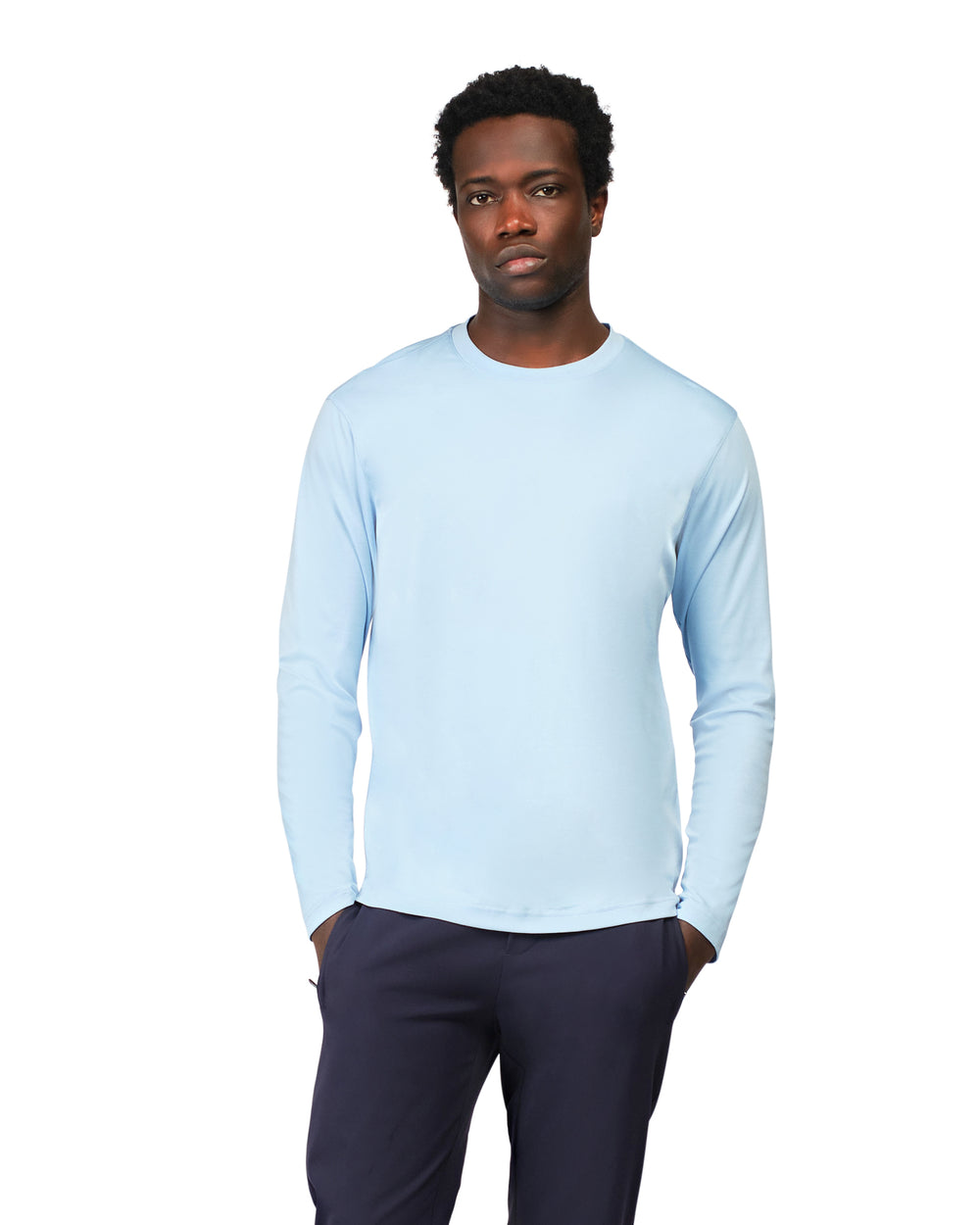 Man wearing a light blue long-sleeve shirt and dark pants on a white background