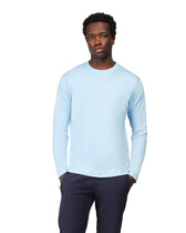 Man wearing a light blue long-sleeve shirt and dark pants on a white background