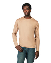 Man wearing a beige long-sleeve shirt and blue jeans on a white background