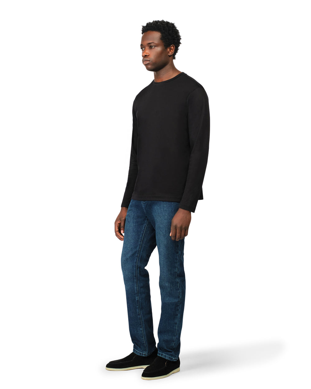 Man wearing a black long-sleeve shirt and blue jeans on a white background