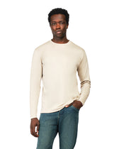 Man wearing a beige long-sleeve shirt and blue jeans on a white background