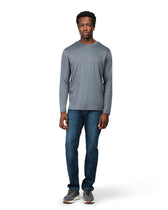 Man wearing a gray long-sleeve shirt and blue jeans on a white background