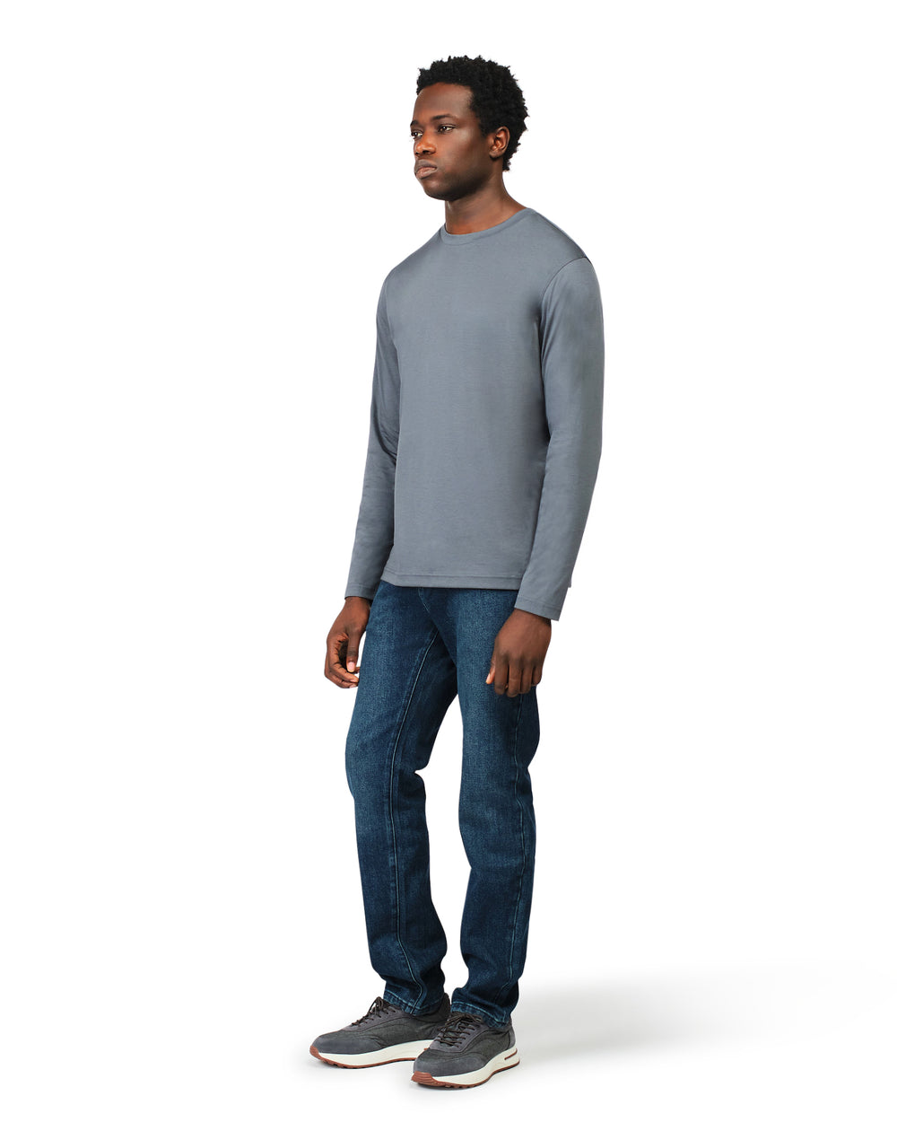 Man wearing a gray long-sleeve shirt and blue jeans on a white background