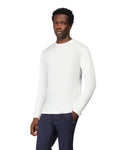 Man wearing a white long-sleeve shirt and dark pants on a white background