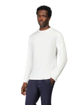 Man wearing a white long-sleeve shirt and dark pants on a white background