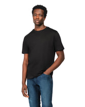 Man wearing a black t-shirt and blue jeans on a white background