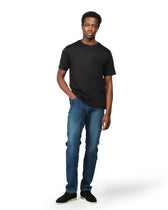 Man wearing a black t-shirt and blue jeans on a white background