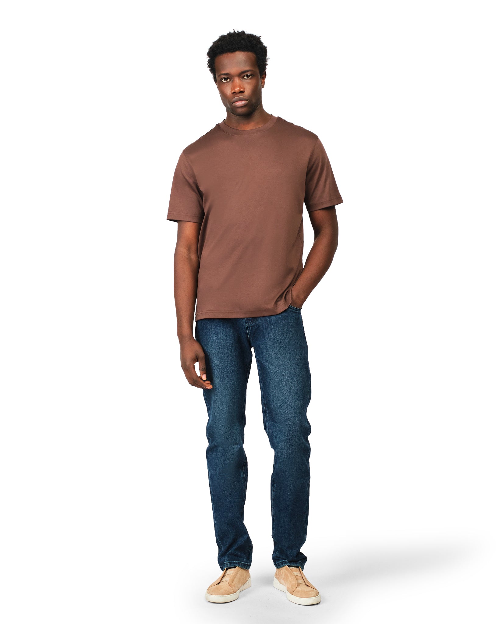 Man wearing a brown t-shirt and blue jeans on a white background
