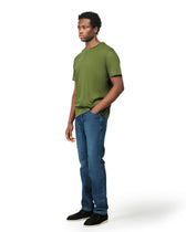 Man wearing a green t-shirt and blue jeans on a white background