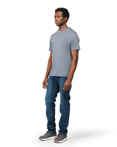 Man wearing a gray t-shirt and blue jeans on a white background
